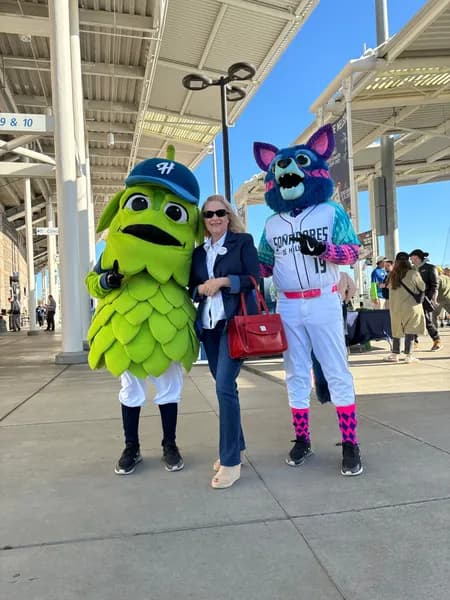 Jenny Kamprath with the Hillsboro Hops mascot and an opposing team mascot at a local ballgame